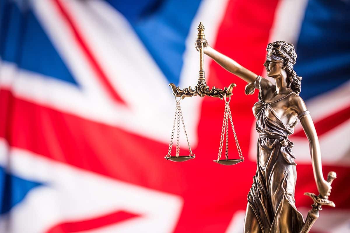 Lady,Justice,And,Flag,Of,United,Kingdom,In,The,Background.
